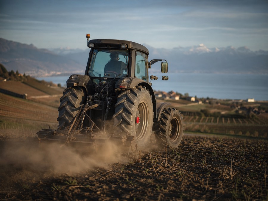Tracteur au travail dans un champ au-dessus du lac